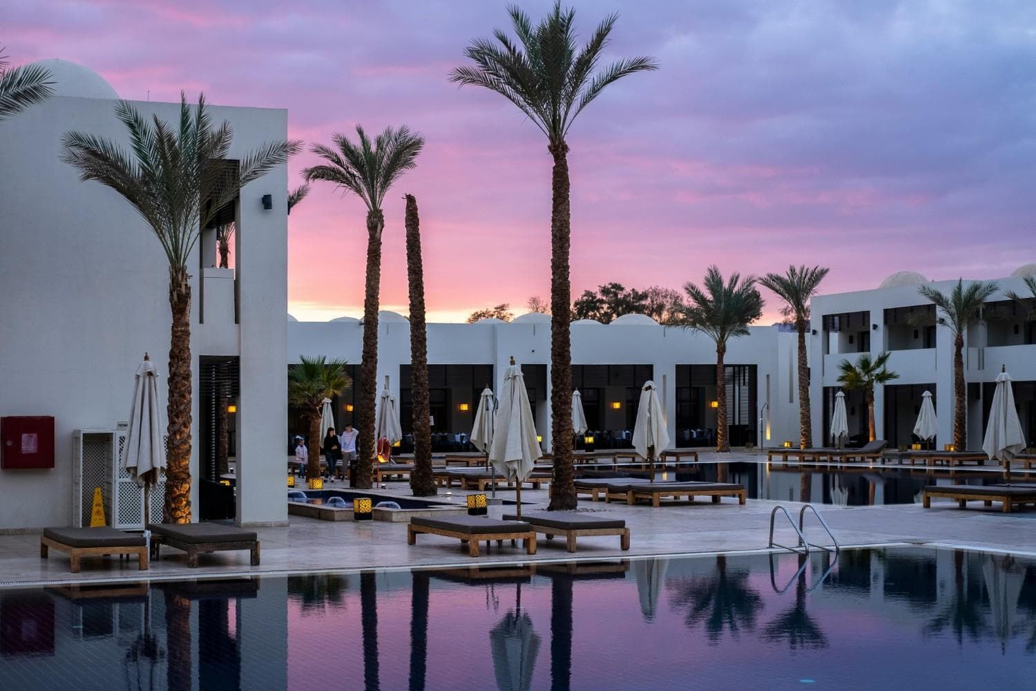 Palm trees at sunset near a resort